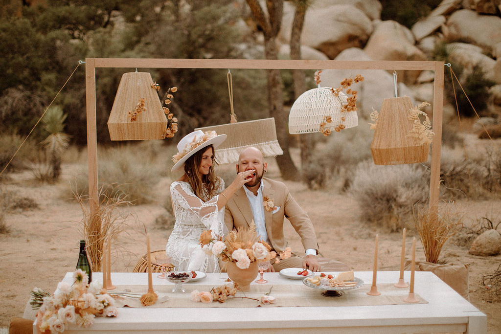 Couple sitting at boho sweetheart table after Joshua Tree elopement