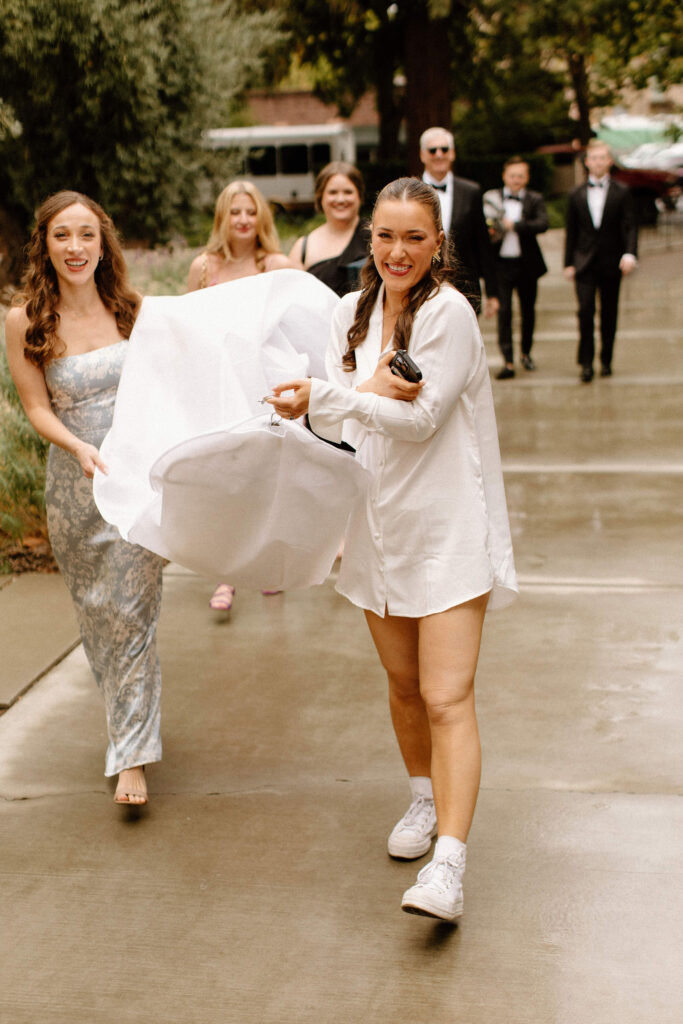 Bride and bridesmaids carrying wedding dress inside