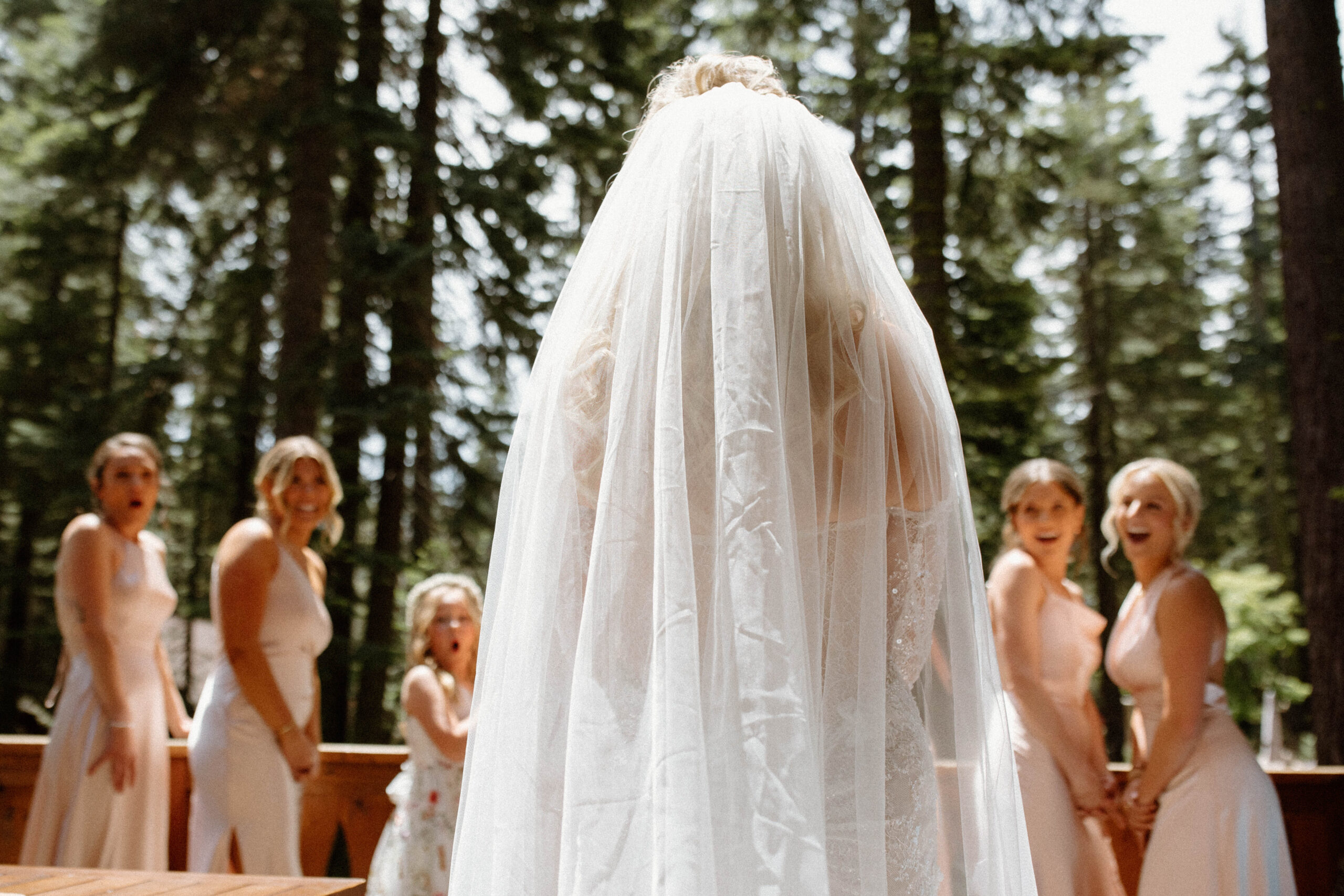 bride poses with her bridesmaids during her first look photoshoot before her Lake Tahoe Wedding at Dancing Pines