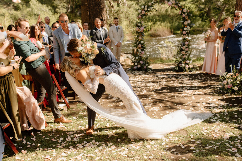 bride and groom share a kiss during their exit from their Lake Tahoe Wedding at Dancing Pines