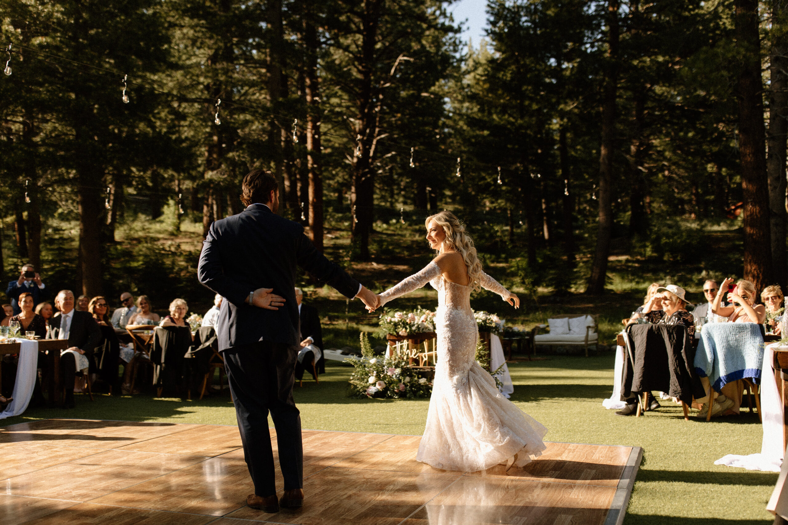bride and groom share a first dance together while their guests look on