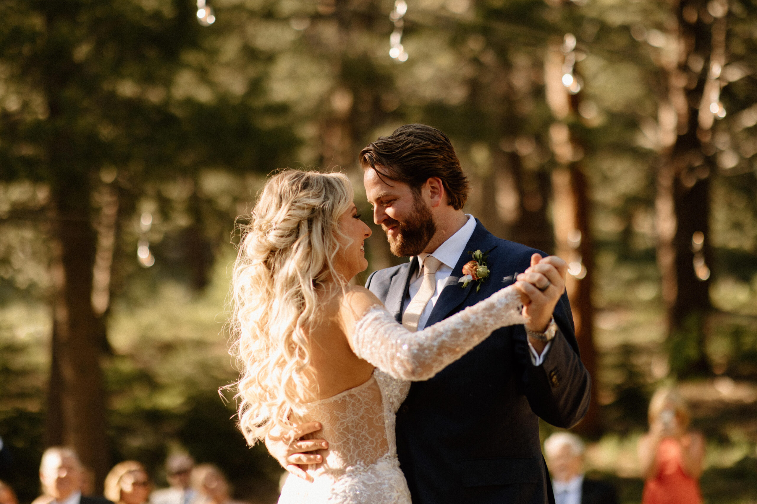 bride and groom share a first dance together while their guests look on