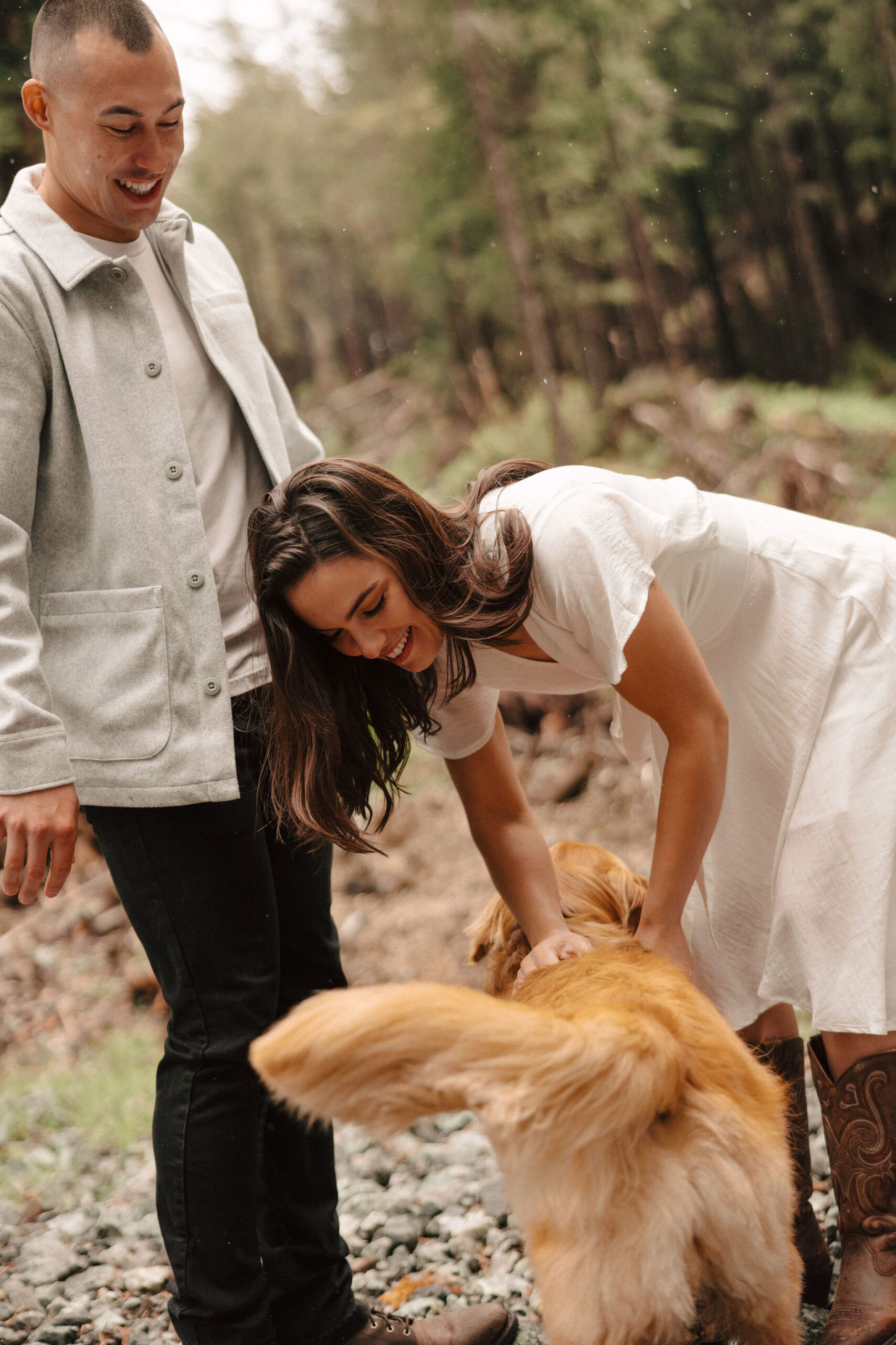 couple pose together on the California coast their beautiful dog