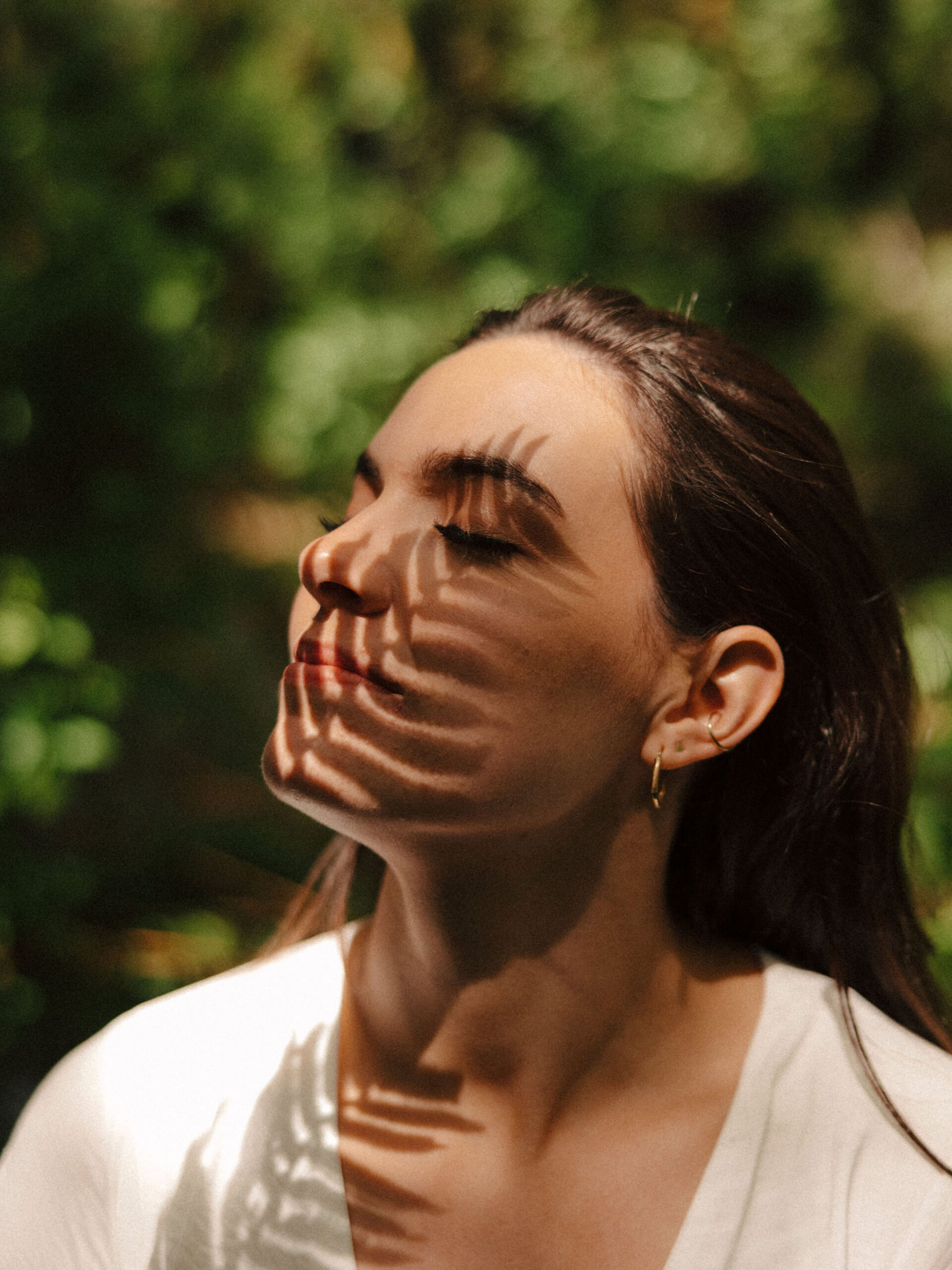 stunning lady poses with the leaves shadows on her face