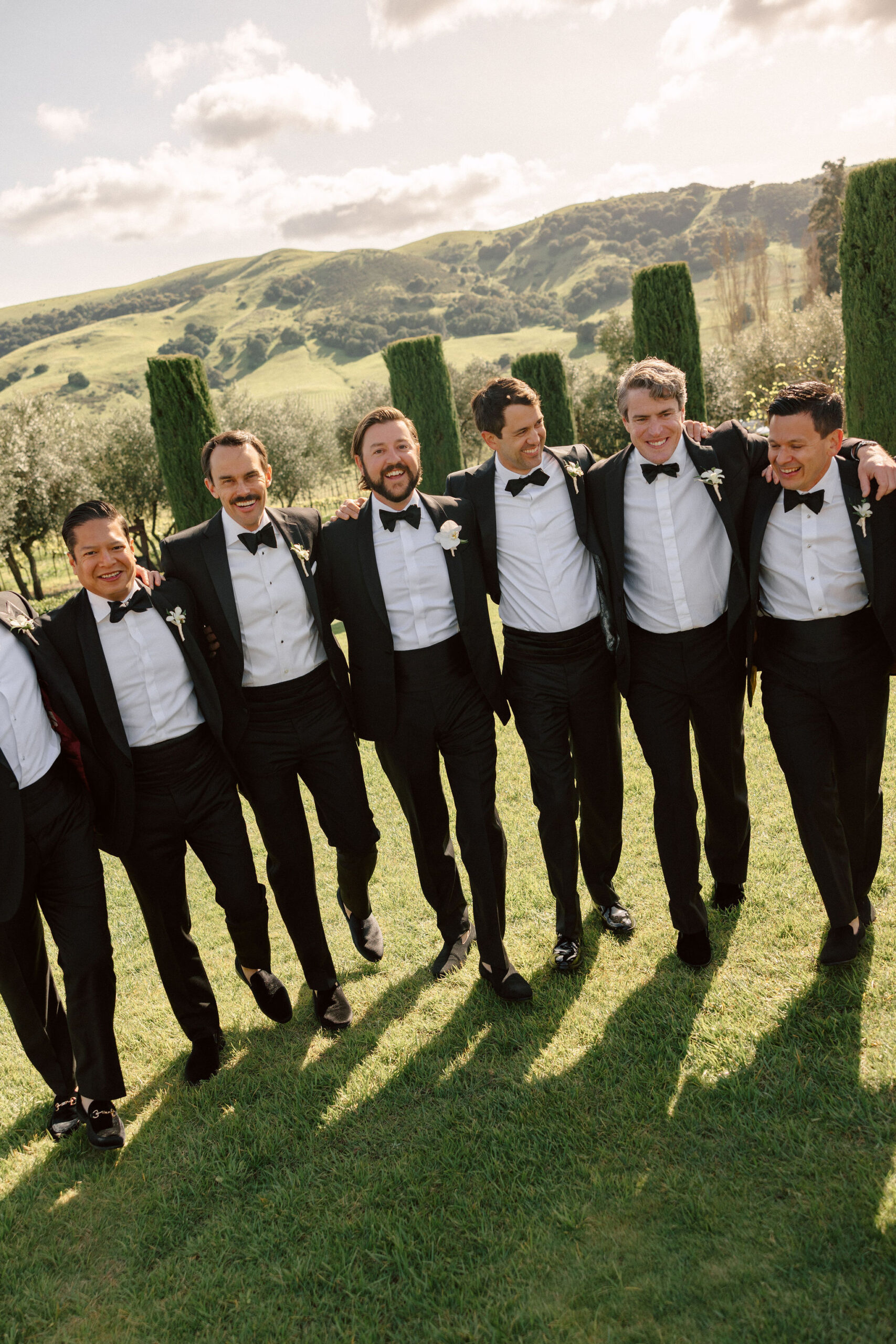 groom poses with his groomsmen after his stunning winery wedding day