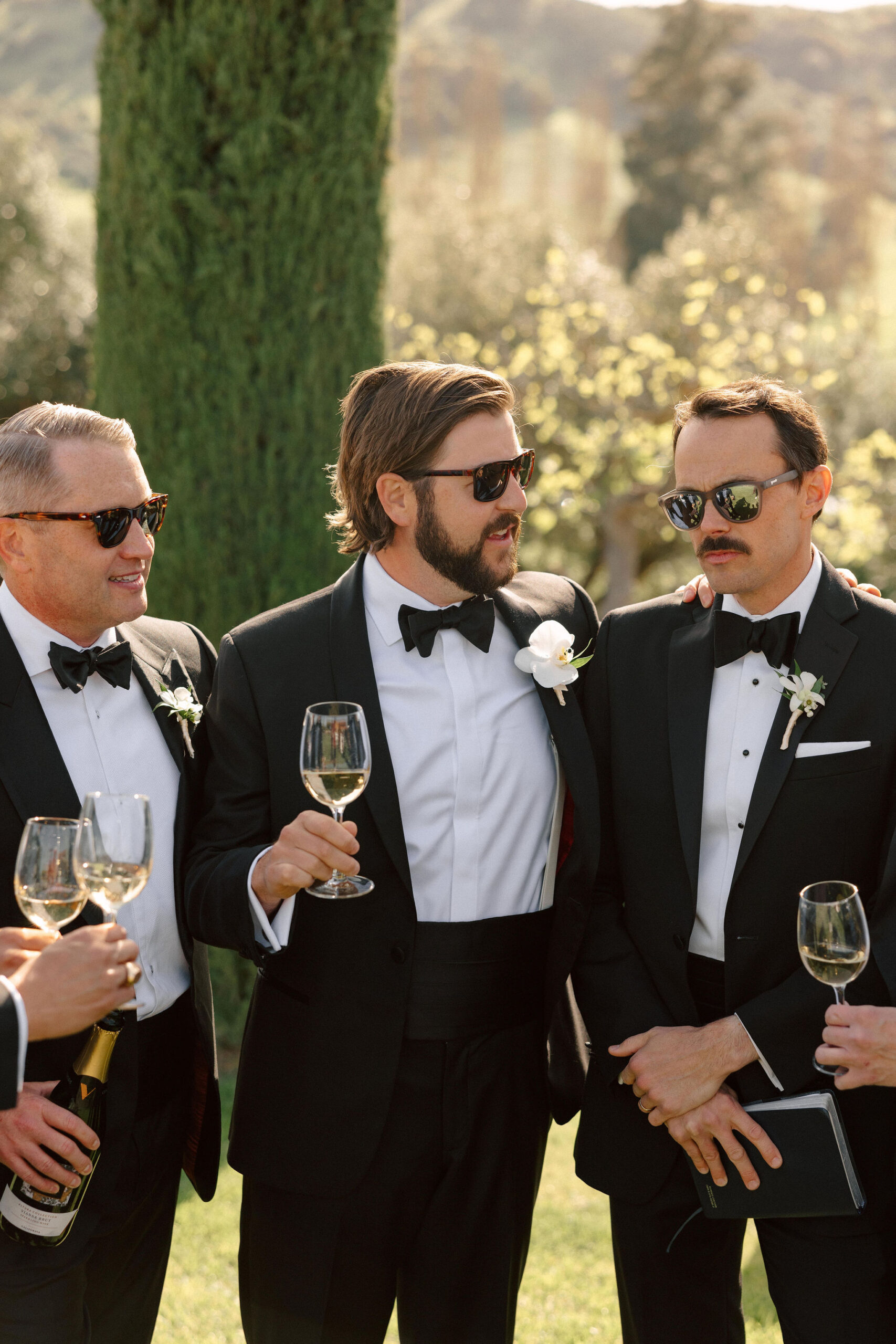 groom poses with his groomsmen after his stunning winery wedding day