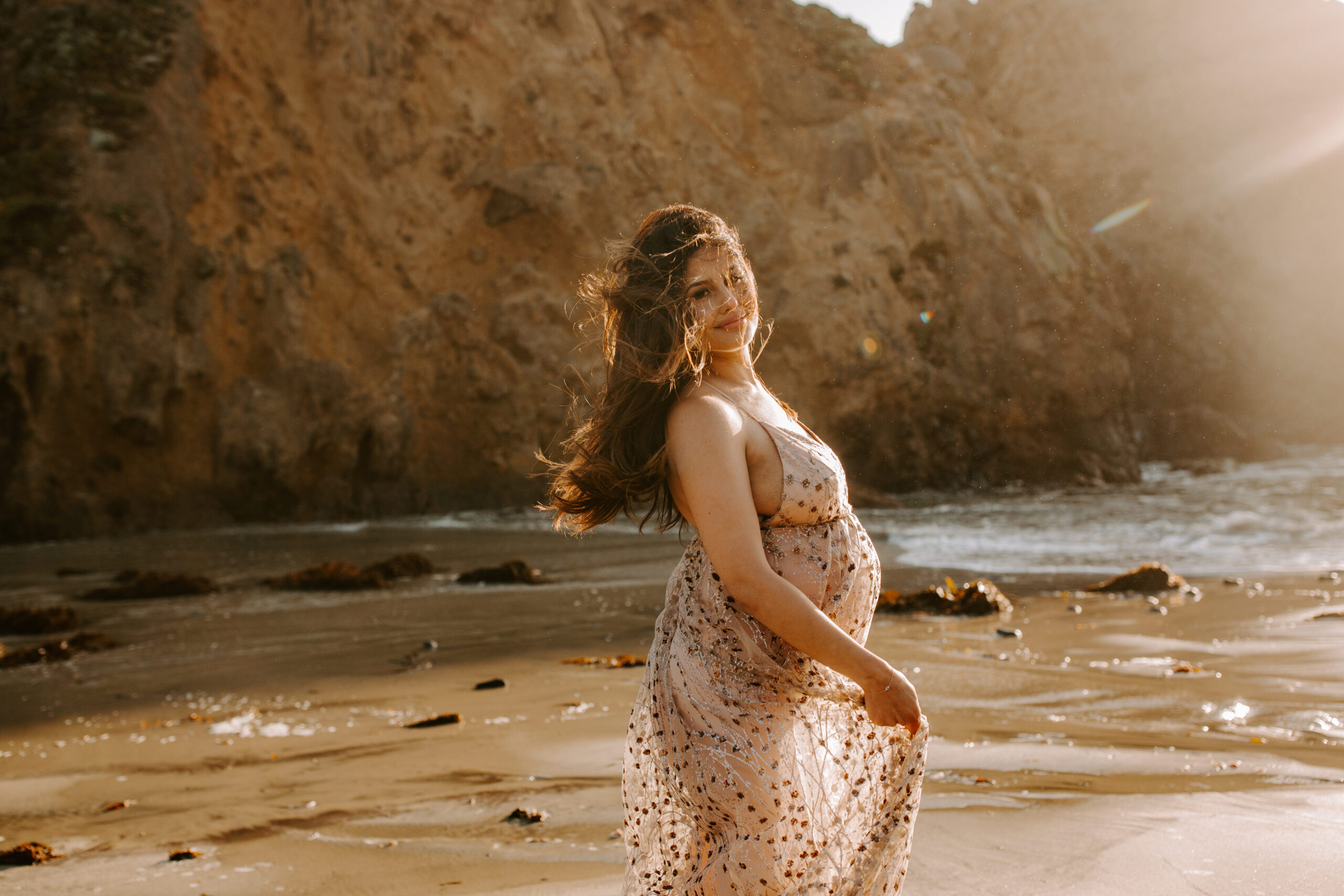 future mom poses on the coast