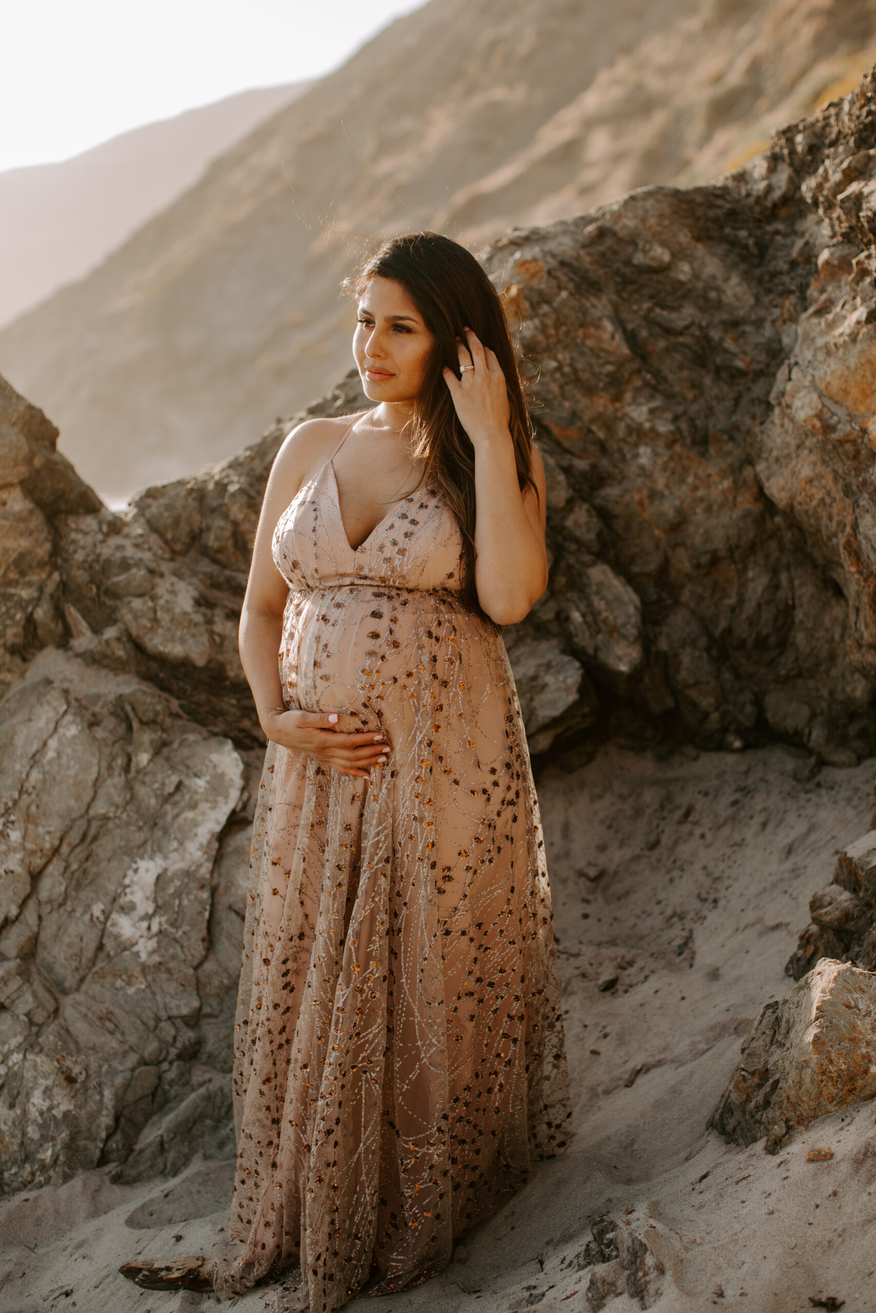 future mom poses on the coast