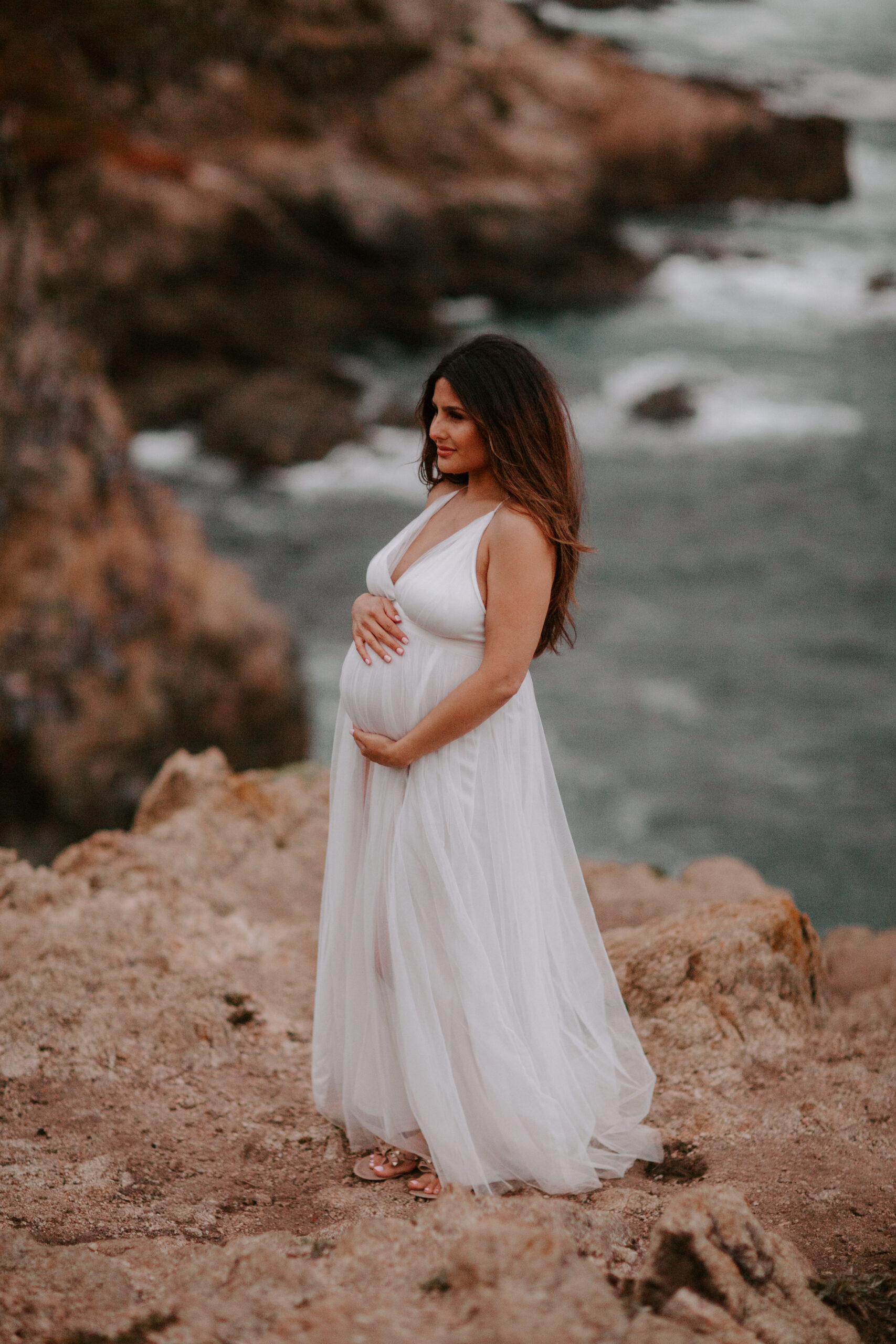 future mom poses on the coast