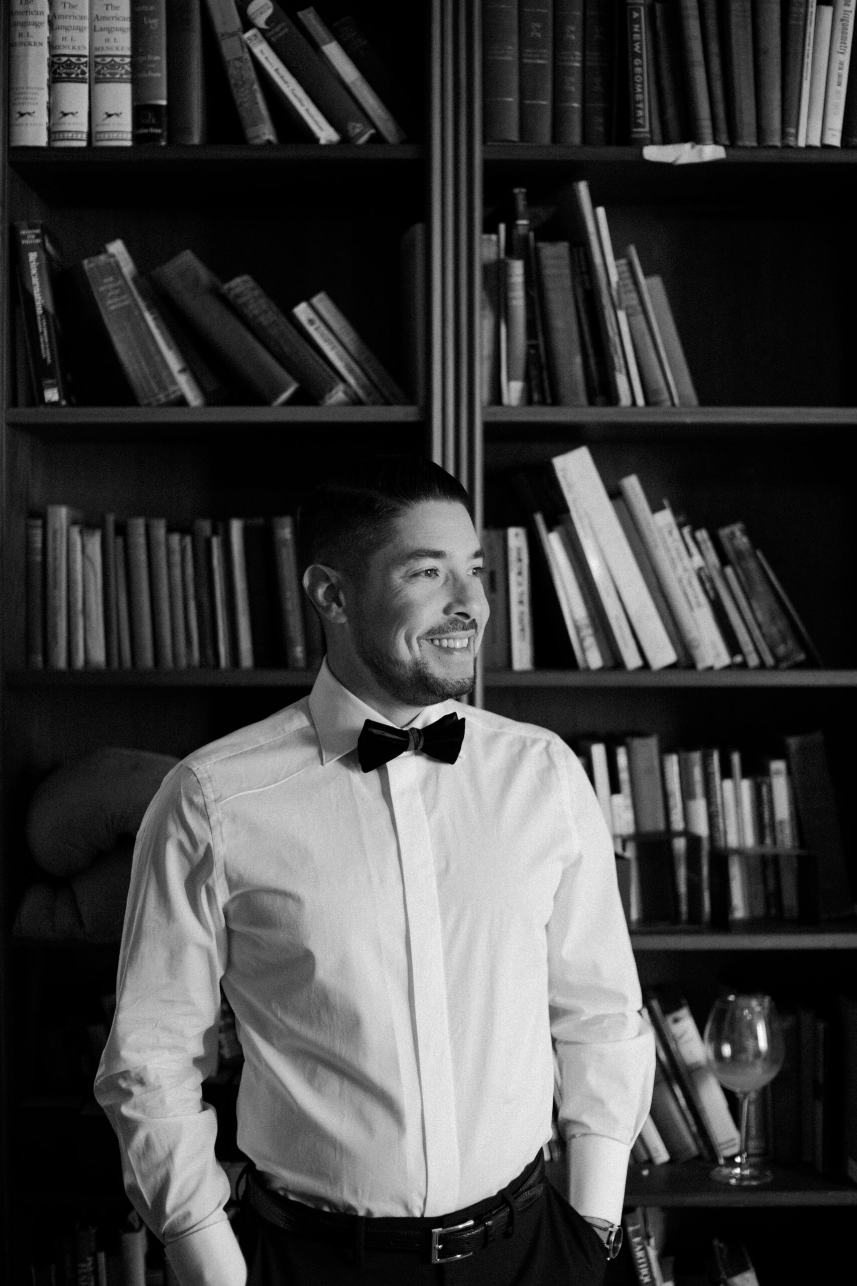 groom poses in the library