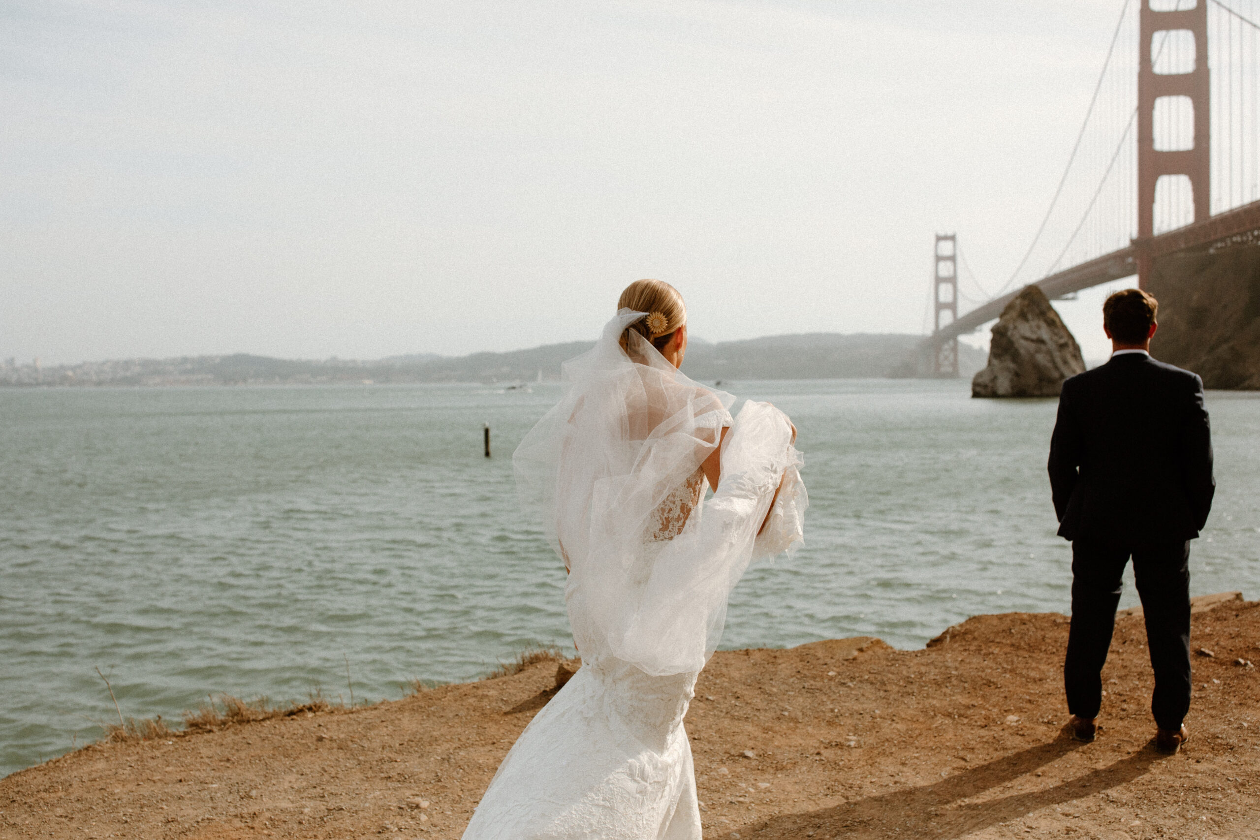 bride poses on the California beach after her dreamy wedding day