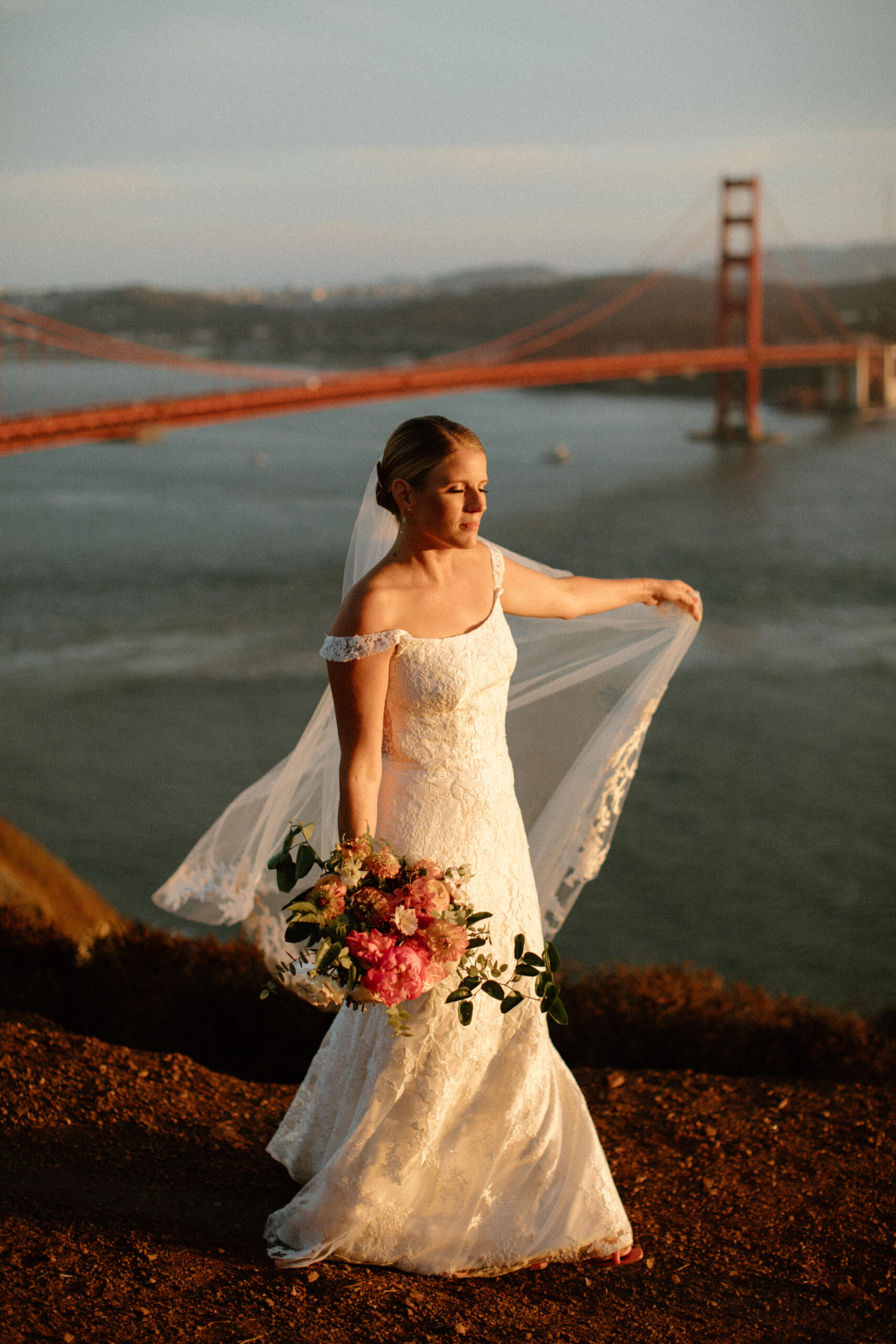 bride poses with the golden gate bridge behind her