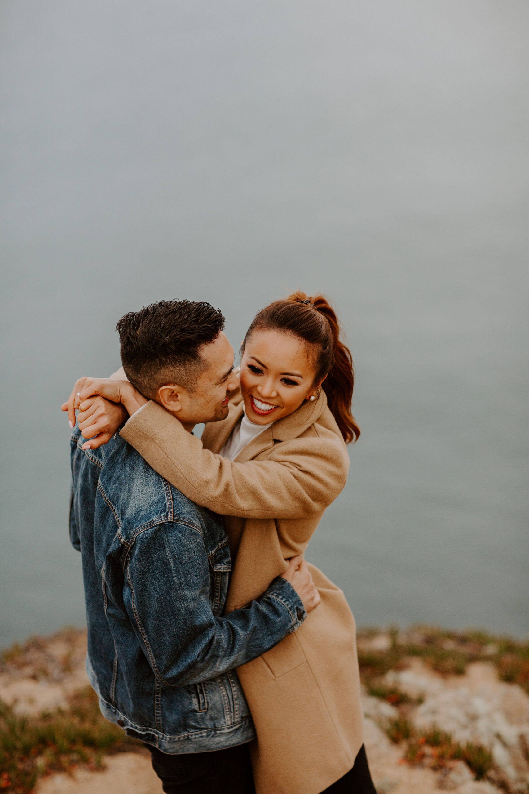 beautiful couple pose with the Pacific ocean in the background, a top tier San Francisco engagement photoshoot location!