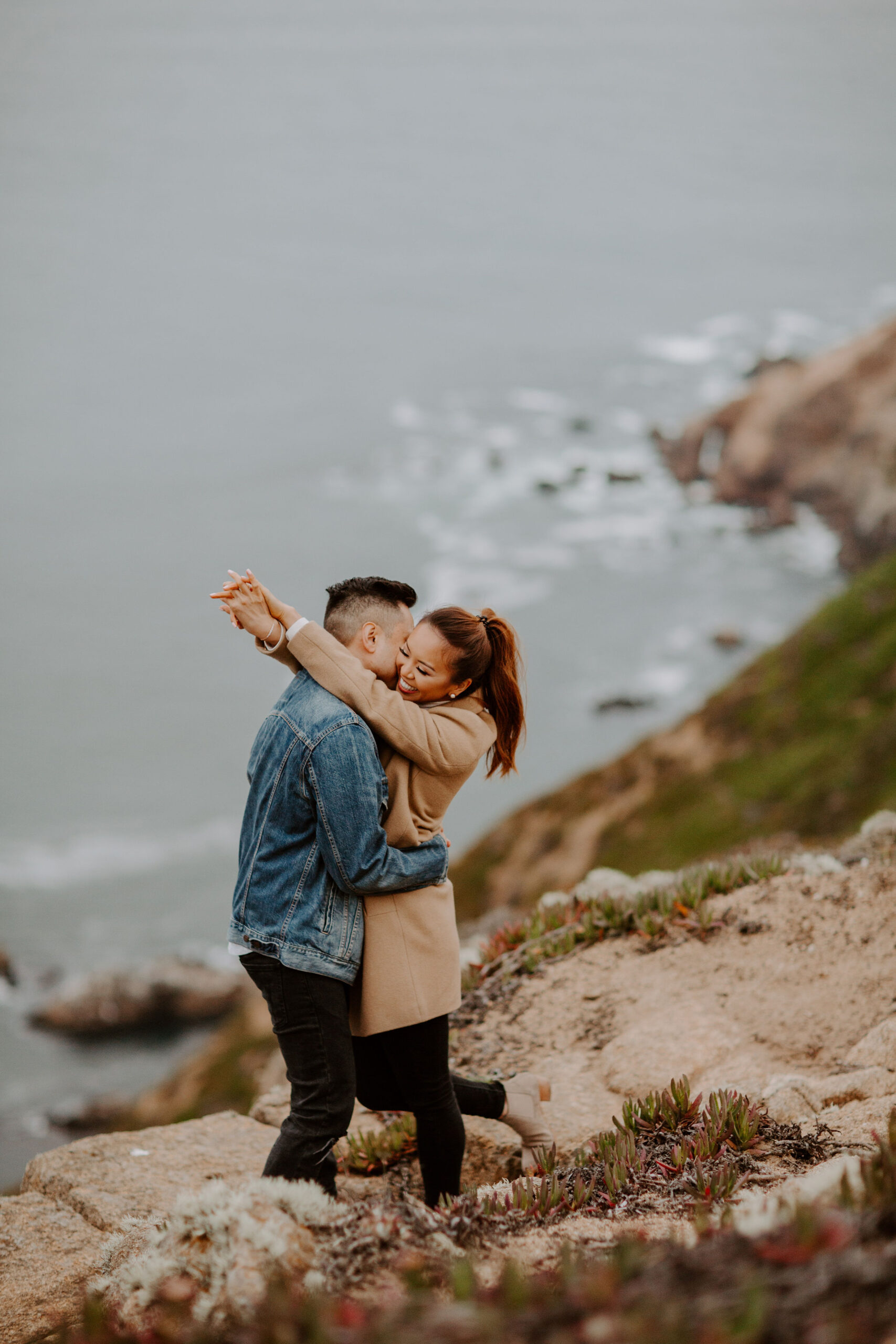 beautiful couple pose with the Pacific ocean in the background, a top tier San Francisco engagement photoshoot location!