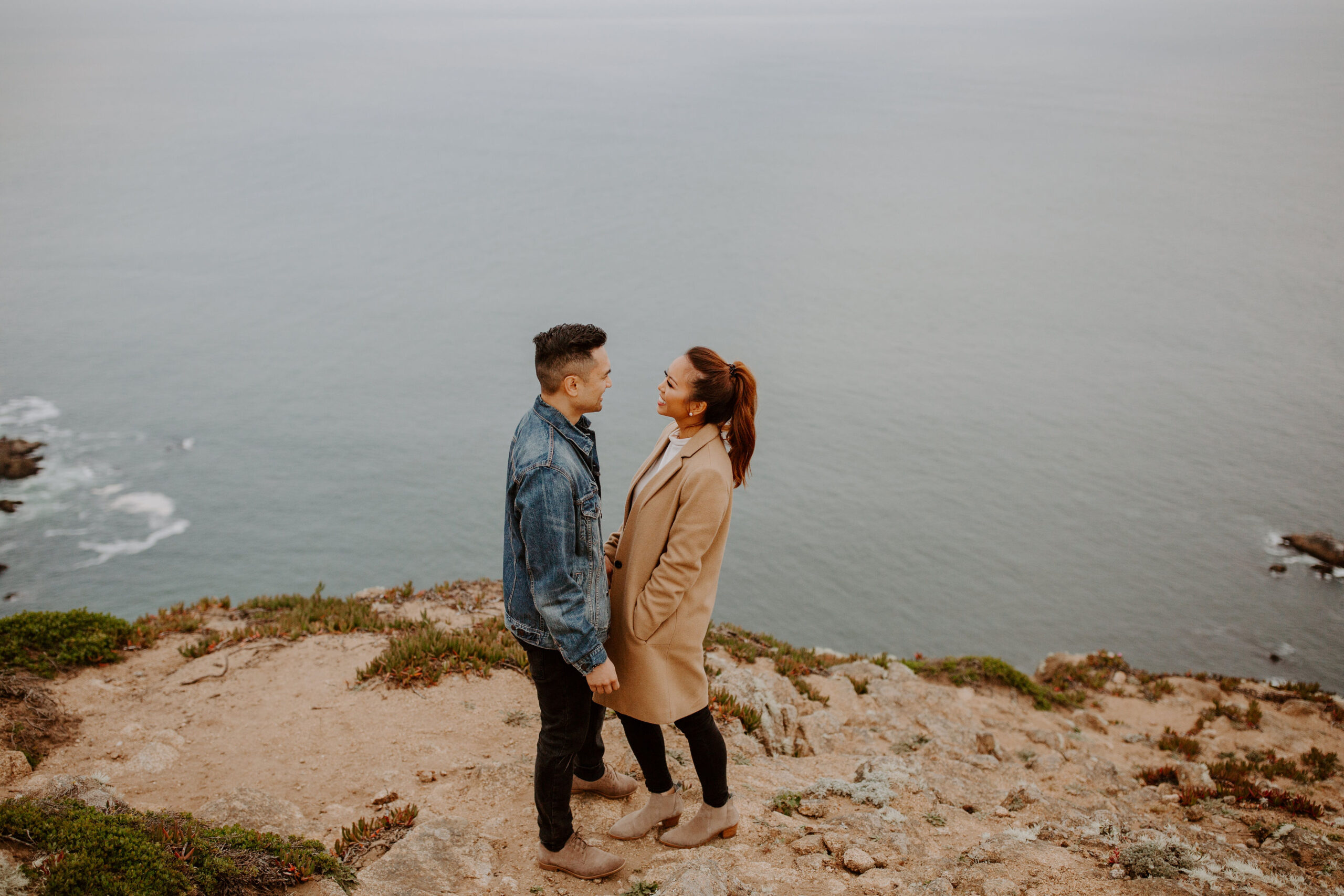 beautiful couple pose with the Pacific ocean in the background, a top tier San Francisco engagement photoshoot location!