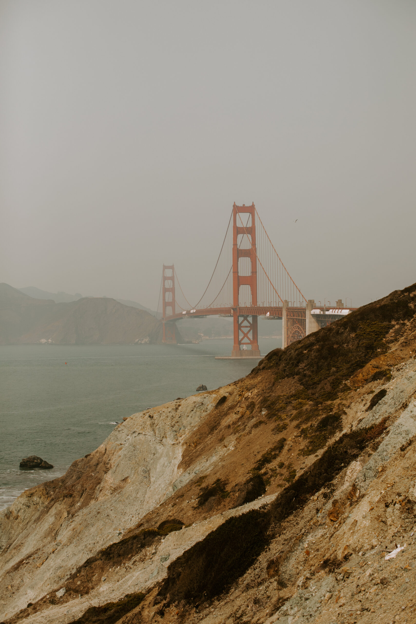 beautiful couple share an intimate moment during their candid California engagement photoshoot with the golden gate bridge in the background